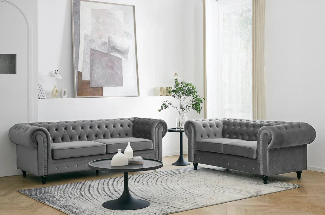 Grey velvet Chesterfield sofa and matching armchair in a modern living room setting