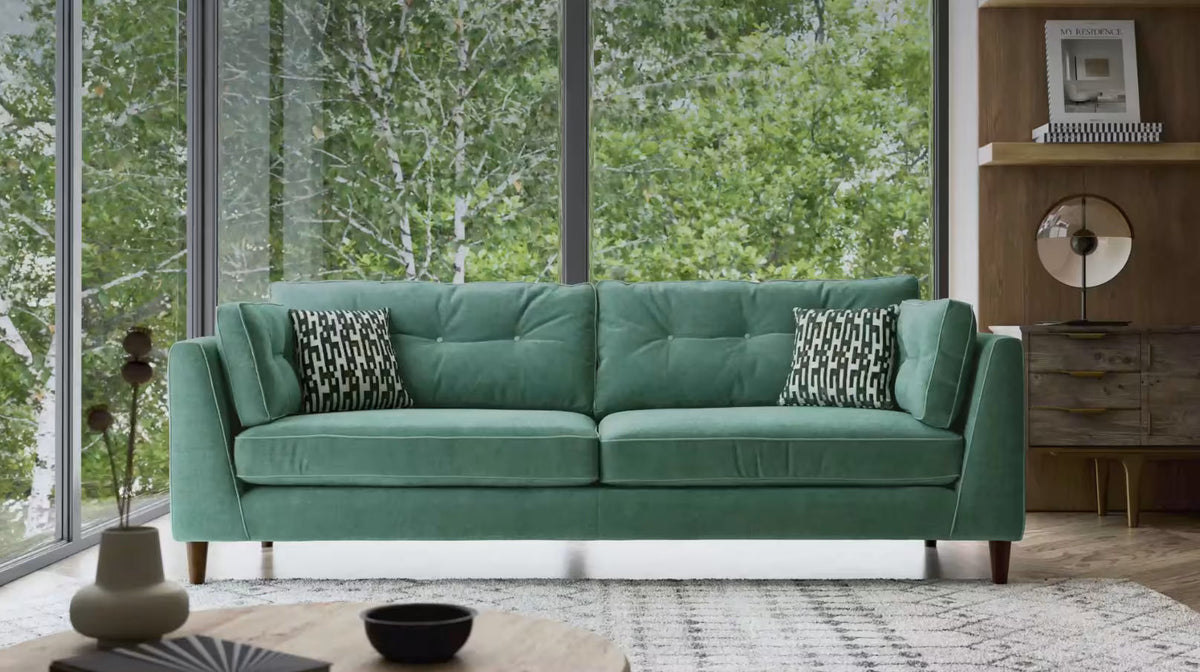 Modern mint green Cricket sofa with patterned cushions in a bright living room
