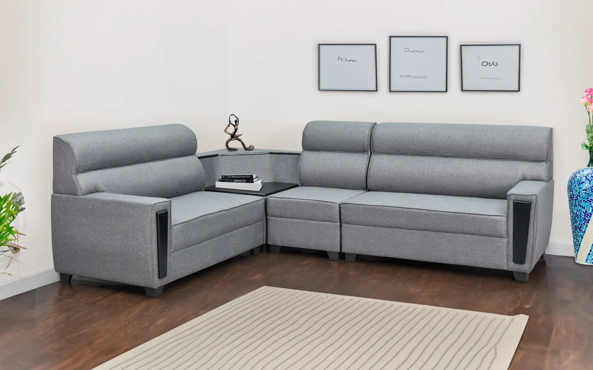 Modern grey fabric corner sofa with integrated side table in a minimal living room