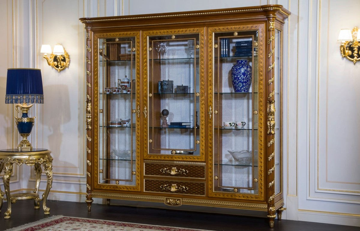 Ornate 3-door wooden vitrine display cabinet with gold accents and glass shelving